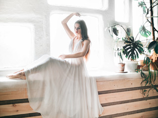 Portrait of beautiful balerina woman weared in white dress. Studio shot, natural light	