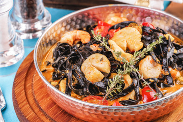  Mediterranean black pasta with shrimps, tomatoes, dumplings, rosemary and mushrooms