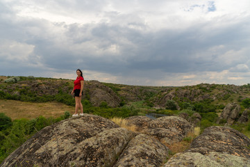 Large granite canyon. Village Aktove. Ukraine. Beautiful stone landscape. Woman 35 years old brunette tourist on the canyon.