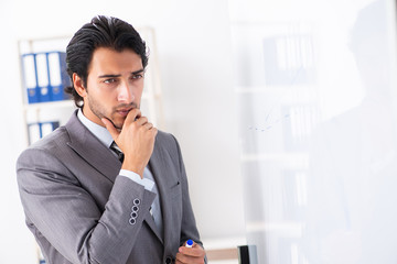 Young handsome businessman in front of whiteboard