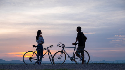 couple cyclist on background of sunset, sport and travel concept