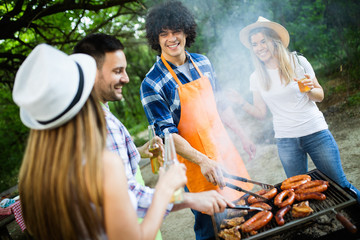 Friends having a barbecue party in nature while having fun
