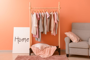 Rack with hanging clothes in interior of dressing room