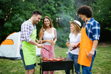 Group of happy friends having a barbecue party in nature