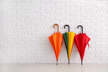 Fotobehang Stylish umbrellas near white brick wall © Pixel-Shot