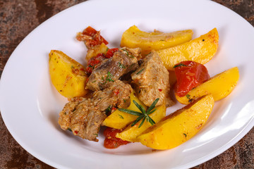 Baked pork meat with potao and tomato
