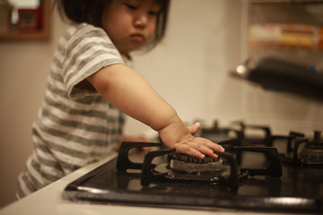 ガスコンロに触れる女の子