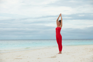 Yoga outdoor. Happy woman doing yoga exercises, meditate on the beach. Yoga meditation in nature. Concept of healthy lifestyle and relaxation. Pretty woman practicing yoga near the sea