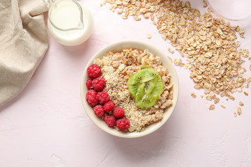 Bowl with tasty sweet oatmeal and milk on light background