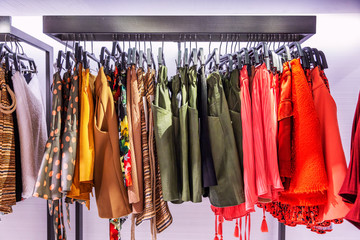 Women's clothing on rail in the store. Skirts of different colors and textures. Close-up.