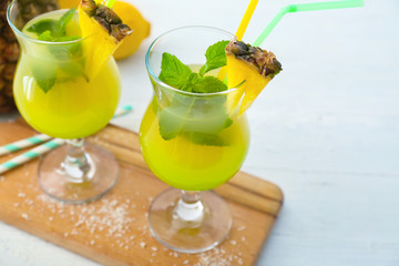 Glasses of fresh cocktail with pineapple juice on table