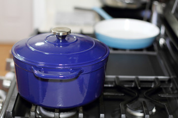 Porcelain enameled Dutch oven and skillet on the stove top in a home kitchen.
