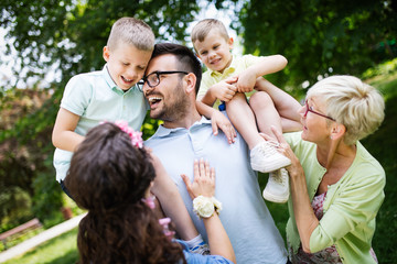 Happy family playing and enjoying picnic with children outside