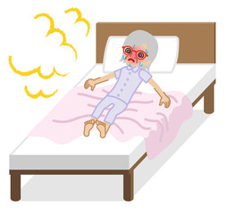 ベッドの上で熱中症に苦しむシニア女性