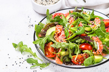 Salmon salad with fresh vegetables on white.