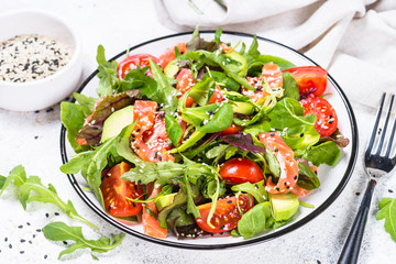 Salmon salad with fresh vegetables on white.
