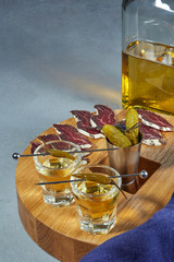 whiskey in two glasses and sliced jerky with spices on the oak surface