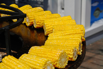 Delicious golden corns on large barbecue fire bowl