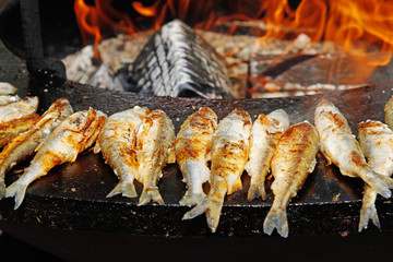 Fried smelts on large barbecue fire bowl