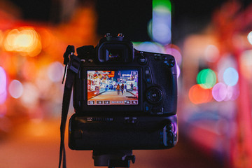 Photograph of a camera doing long exposure in a fun fair. France.