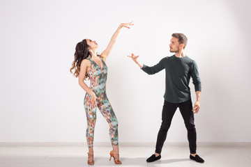 Fototapeta premium Social dance, bachata, kizomba, tango, salsa, people concept - Young couple dancing over white background with copy space