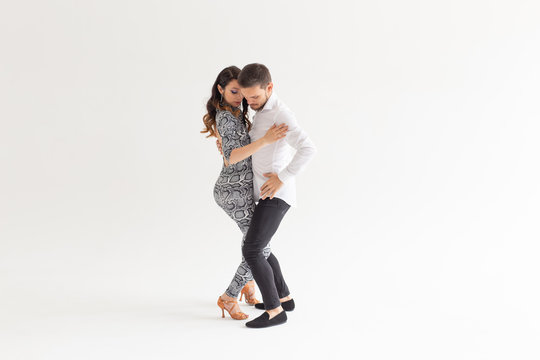 Social dance, bachata, kizomba, zouk, tango concept - Man hugs woman while dancing over white background with copy space