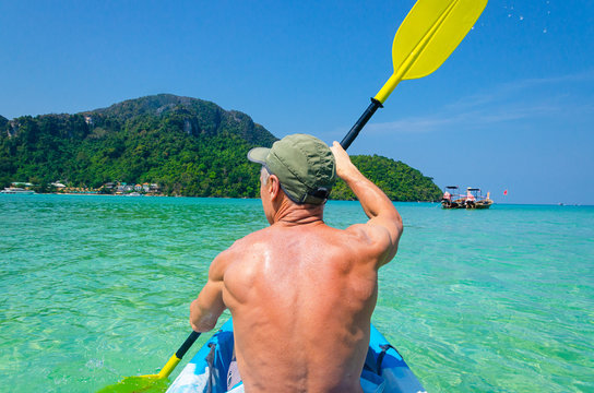 un uomo musculoso rema kayak in tailandia phi phi koh poda