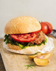 High angle close-up burger with fries on wooden board