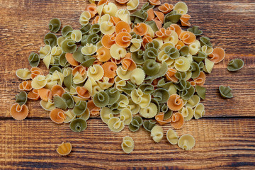 pasta colorata сolorful spaghetti, conchiglie, conchiglioni, macaroni on wooden background close up selective focus