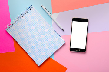 clean notepad with pen and smartphone with white screen for layout