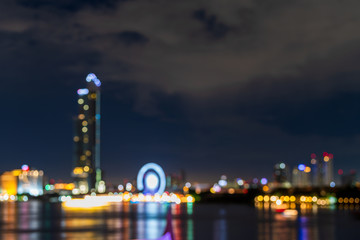 Naklejka premium Abstract blur with bokeh light background image of Asiatique the riverfront with skyscraper and Chao Phraya River at night in Bangkok, Thailand.
