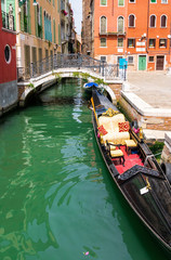 Fototapeta na wymiar picturesque view at a Venezia chanel vith gondola and nice old builginds around