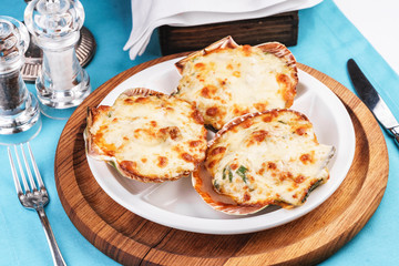 European recipe, Mediterranean dish. Baked mollusks in the oven under the cheese cap and greens according to the national recipe