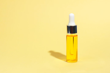 Dropper glass Bottle Mock-Up. Serum skin care cosmetics on yellow background, banner or template. Beauty product concept.