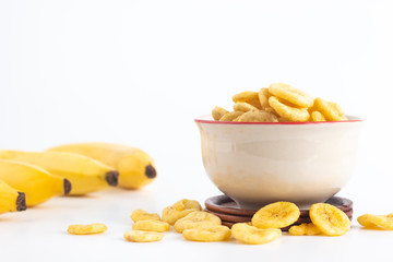 Banana with dried banana slices in a cup isolated on white background