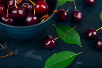 Ripe sweet cherry in a black bowl