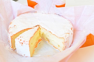 Top view of Camembert cheese with a separate slice near.