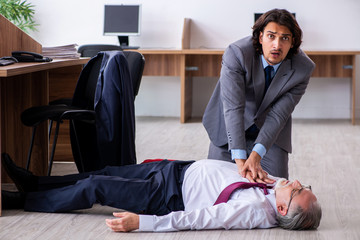Male employee suffering from heart attack in the office