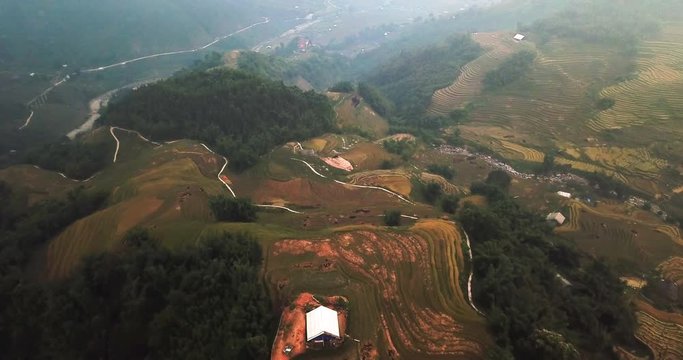Sapa, Vietnam, rice fields on the hills, village houses and road, descending drone dolly in shot