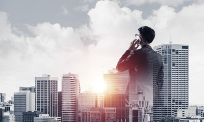 Concept of business success and control with confident boss against cityscape background