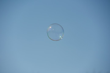 Soap bubble flies away in a cloudless sky