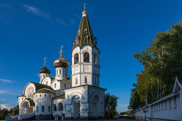 Fototapeta na wymiar Russian Orthodox white-stone church with green domes