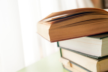 Open book, hardback books on bright colorful background.