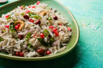 Dapde Pohe is a typical Maharashtrian breakfast, made with thin variety of poha and fresh coconut with chilli, peanuts and nuts. served in a bowl or plate. selective focus