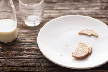 Pieces of biscuit and some milk on rustic table