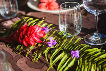 Table setting with tropic flowers and tableware