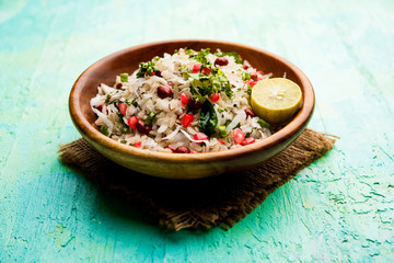 Dapde Pohe is a typical Maharashtrian breakfast, made with thin variety of poha and fresh coconut with chilli, peanuts and nuts. served in a bowl or plate. selective focus