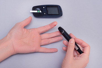 Fototapeta premium Woman use blood glucose detector