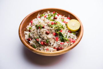 Dapde Pohe is a typical Maharashtrian breakfast, made with thin variety of poha and fresh coconut with chilli, peanuts and nuts. served in a bowl or plate. selective focus
