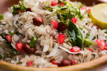 Dapde Pohe is a typical Maharashtrian breakfast, made with thin variety of poha and fresh coconut with chilli, peanuts and nuts. served in a bowl or plate. selective focus